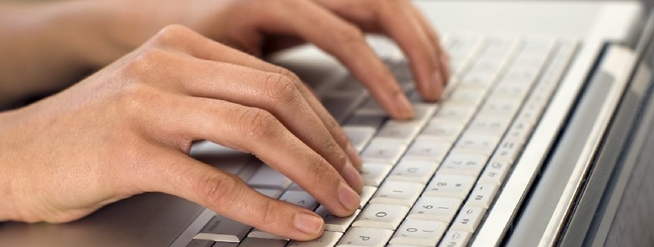 Hände auf einer Laptop-Tastatur